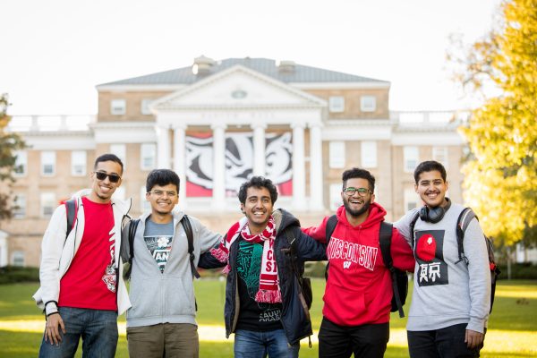 5 students wrapping arms around each other in front of Bascom Hall.