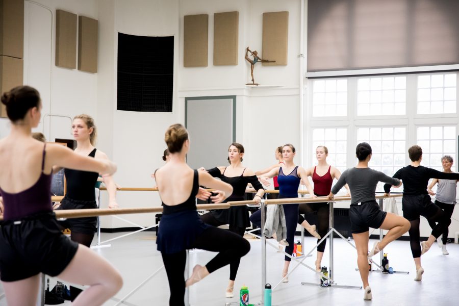 Ballet dancers posing on bar.