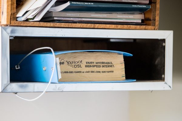 Blue phone book in metal slot with stamped text.