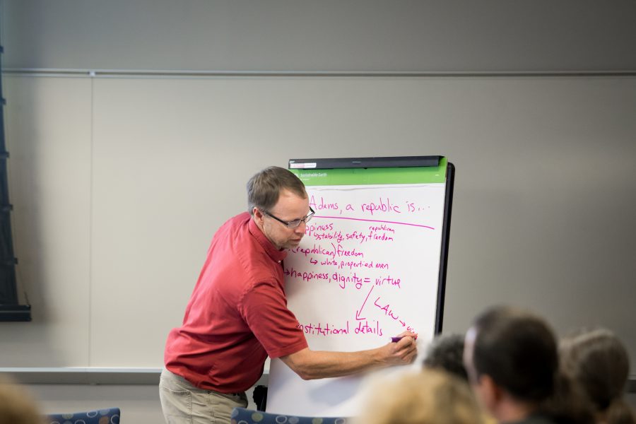 Individual writing on a large notepad for a group of people