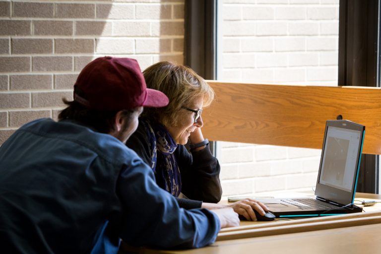 Student working with a tutor in the Merit Library.