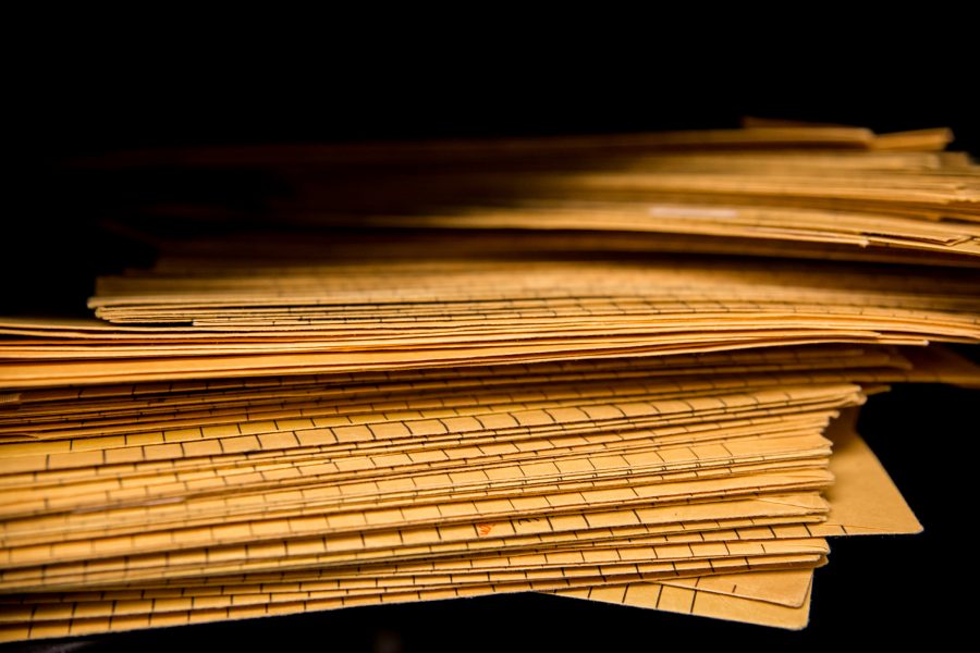 Stack of yellow orange mail envelopes in dark shadow.