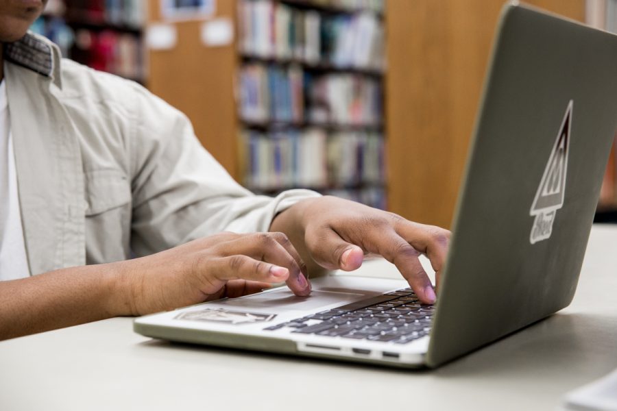 college student working on his computer in the library